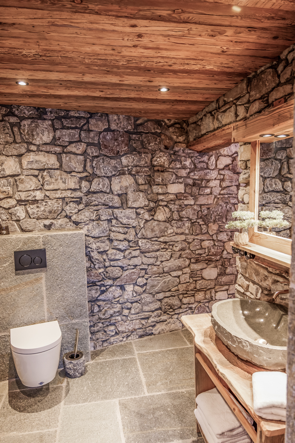 WC-Bereich mit Natursteinwand und Findling-Waschbecken, Schlafzimmer II