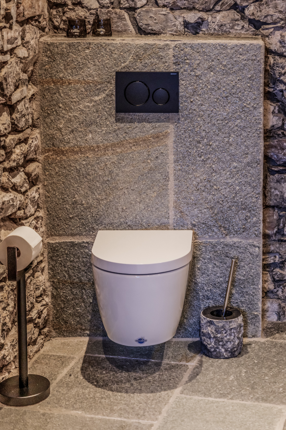 Separates WC mit Natursteinwand im Erdgeschoss
